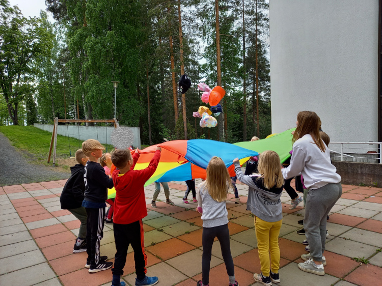 lapset leikkivät leikkivarjolla