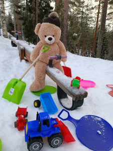 Nalle leikkipuistossa liukureiden ja lapion kanssa