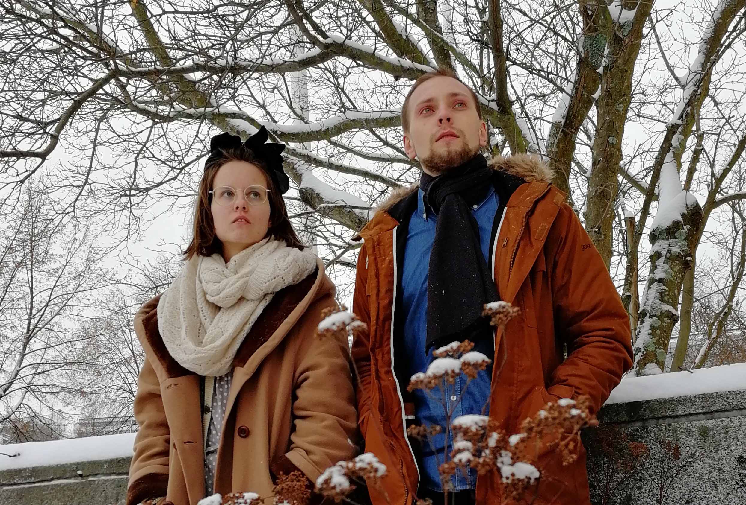 Winterreise Nainen ja mies talvivaatteissa seisovat puun lähellä.