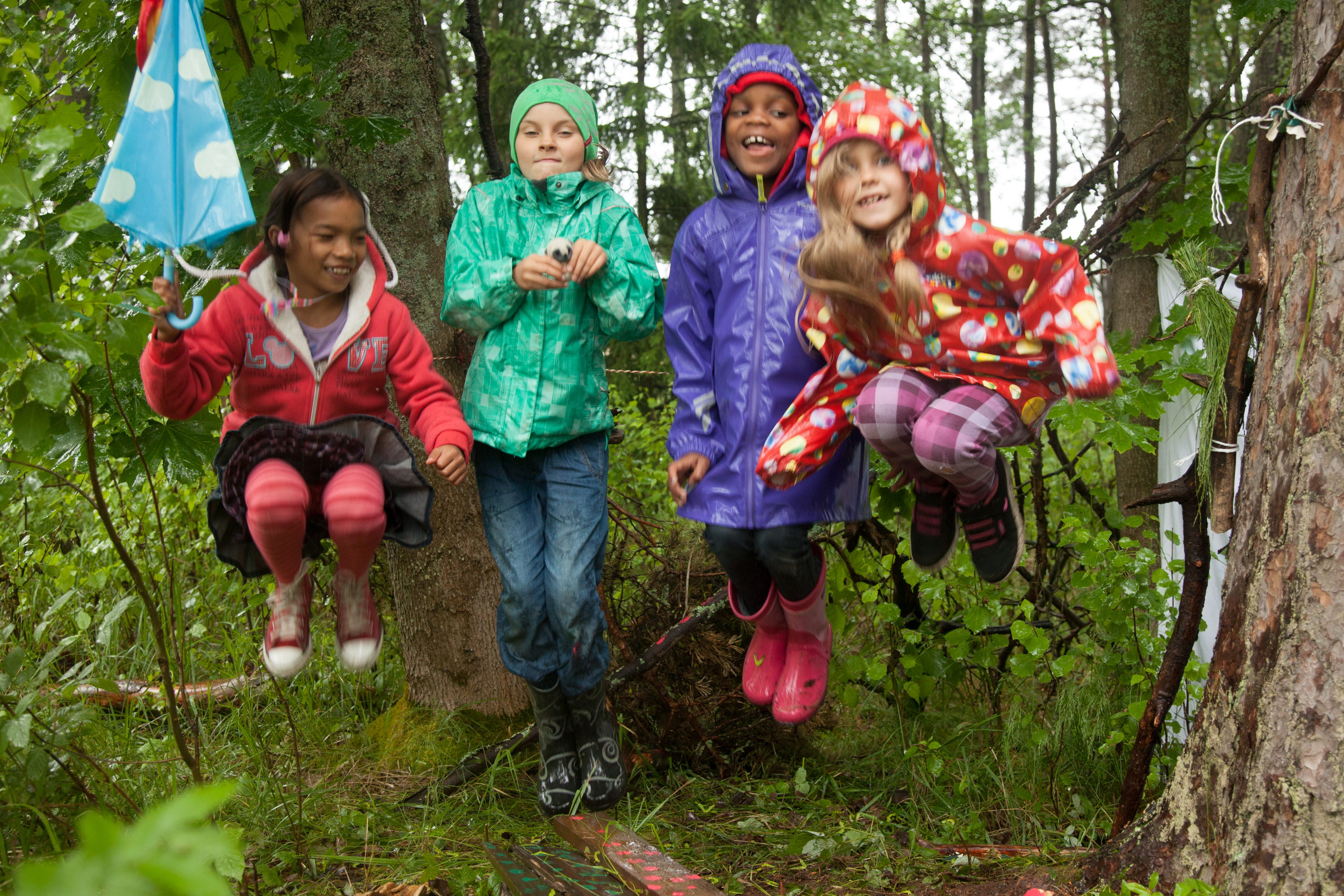 Lapset hyppäävät ilmaan puun suojassa