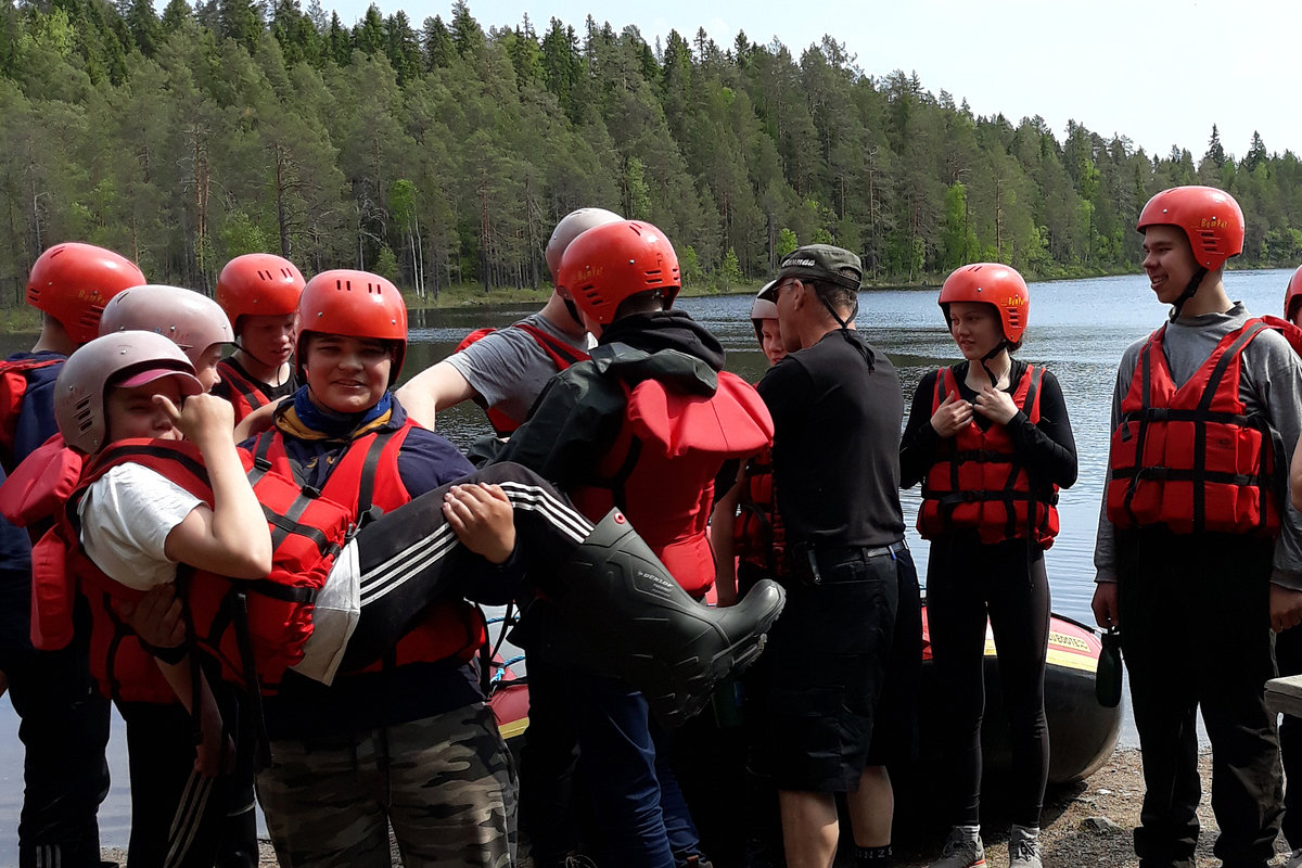 Nuoria pelastusliivit päällä järven rannalla.