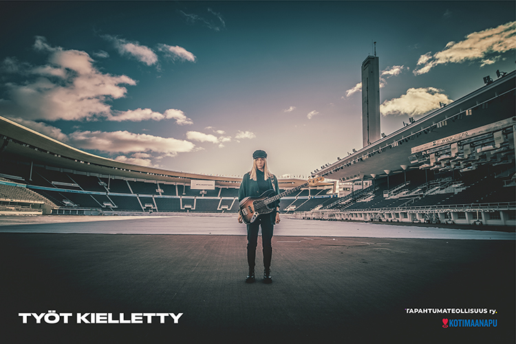 muusikko seisoo keskellä autiota stadionia kitara kädessä