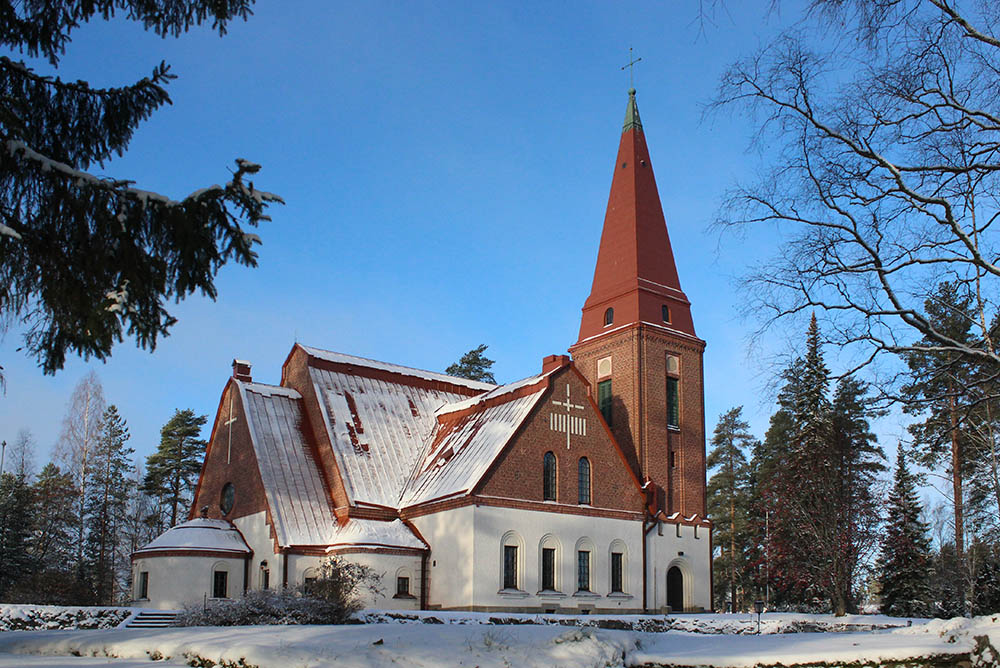 Siilinjärven kirkko talvimaisemassa, etualalla luminen piha.
