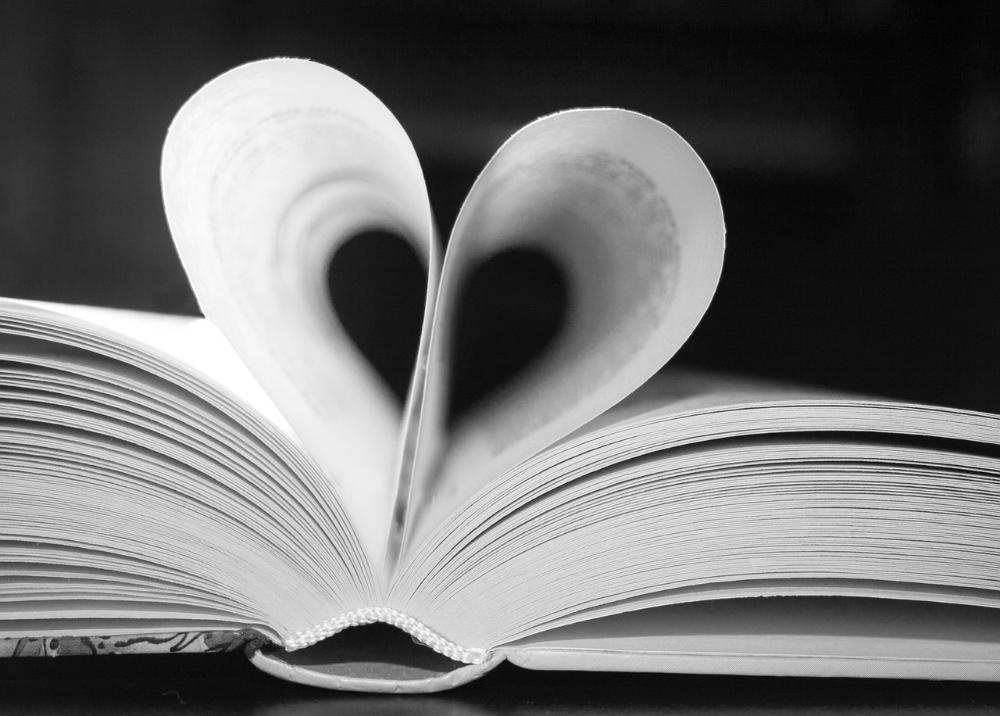 Avoin kirja, jonka keskisivut on taivutettu sydämen muotoon.